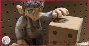 A wooden puppet, looking at a die with no zero on it