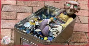 Mme Rigolotte, a wooden puppet, in a box full of buttons