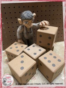 Maurice, a wooden puppet in grey tone, looking at a stack of dice