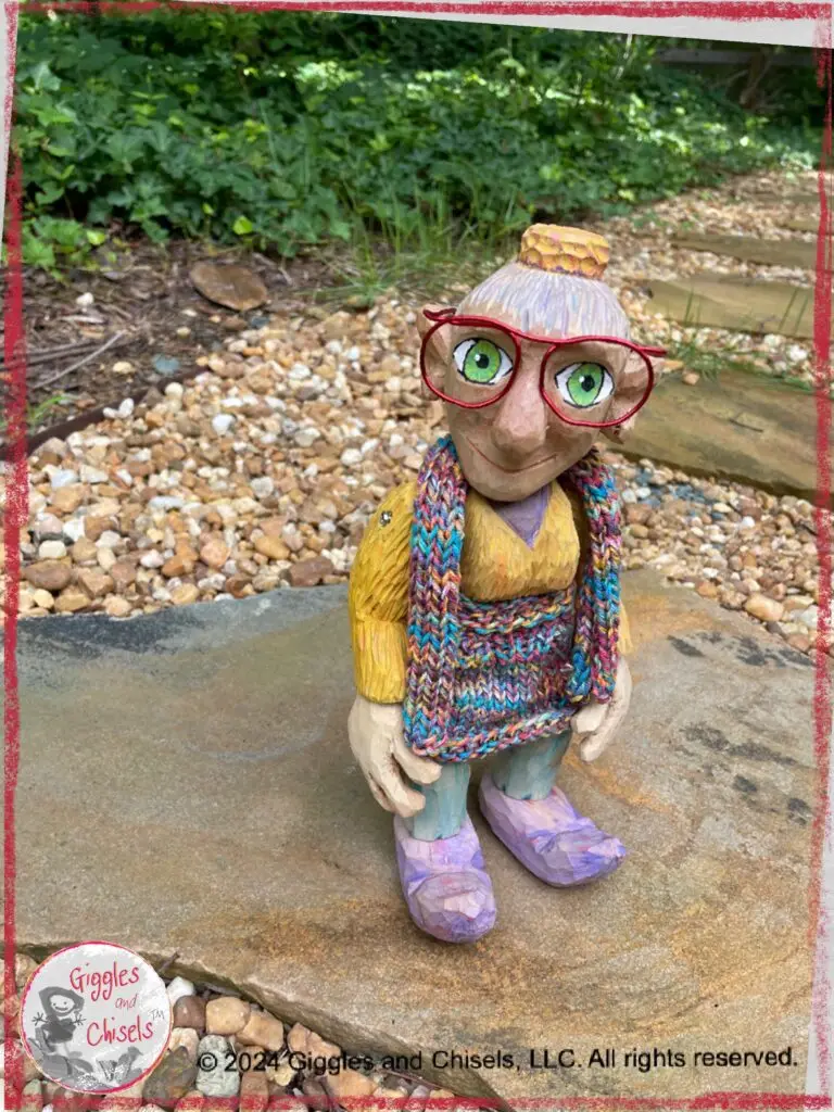 A picture of Mme Rigolotte, a colorful wooden puppet, on a stone path