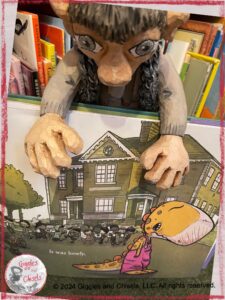 Maurice, a wooden puppet, looking at a page from the book We don't eat our classmates, where one of the characters feel lonely