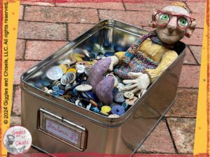 Madame Rigolotte, a wooden puppet, in a "pool" of buttons