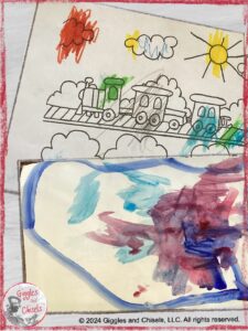 Two pieces of paper: one with a coloring page, one with a a painting, both made by a child under three.