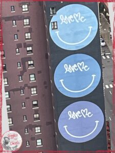 A picture of a wall, with three big circles in purple and blue colors, with love me written on them