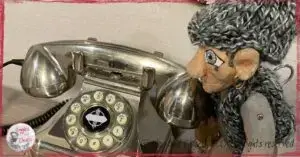 Maurice, a wooden puppet, looking at numbers on a phone