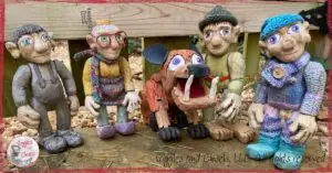 A picture of 6 wooden puppets, in various shades of colors