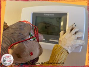 Mme Rigolotte, a colorful wooden puppet, adjusting the temperature of a thermostat