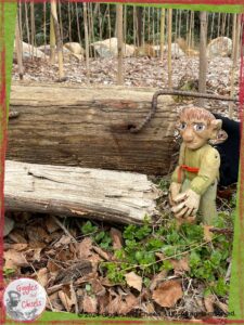 A picture of Pierre Qui Roule, a wooden puppet, in front of a piece of wood that came from a train track