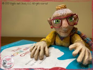 Mme Rigolotte, a wooden puppet, holding the book "The whole-brain child"