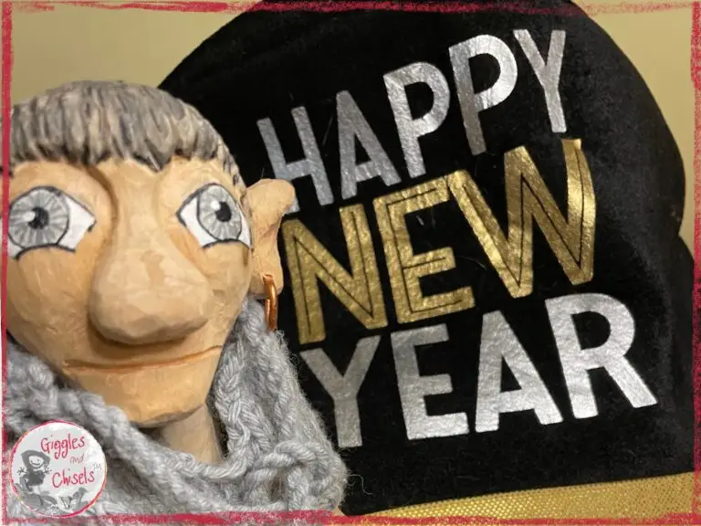 Maurice, a wooden puppet, in front of a hat with Happy New Year