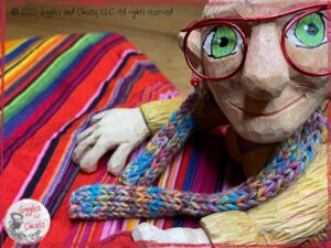 A picture of Mme Rigolotte, a wooden puppet, holding a colorful piece of fabric