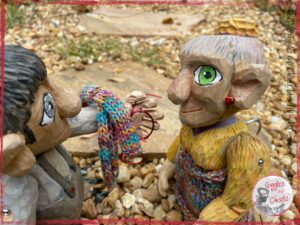 Maurice, a wooden puppet, giving back to Mme Rigolotte, another wooden puppet, her scar and glasses