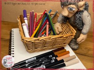 Maurice, a wooden puppet, selecting markers and pencils to draw
