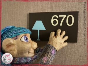 Petite Clothilde, a wooden puppet, spotting a number in a hotel