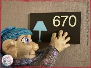 Petite Clothilde, a wooden puppet, spotting a number in a hotel
