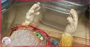 Mme Rigolotte, a wooden puppet, in front of a pile of plastic containers