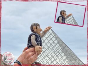Maurice, a wooden puppet, holding the pyramide du Louvre