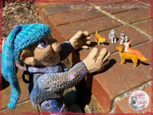 Petite Clothilde, a wooden puppet, inventing a story about cats and dogs
