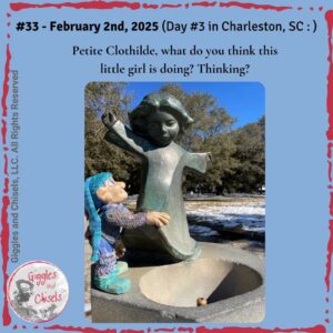 A picture of a wooden puppet, in front of the statue of a little girl, in Chaleston, SC.