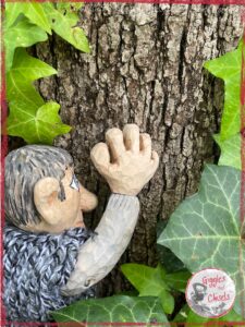 Maurice, a wooden puppet, hugging a tree