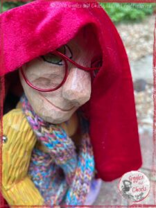 Mme Rigolotte, a wooden puppet, with a red cloth on her head