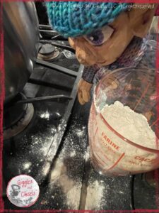 Petite Clothilde, a wooden puppet, measuring flour with a measuring cup