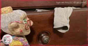 Mme Rigolotte, a wooden puppet, in front of a drawer full of socks