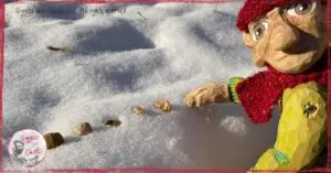 Pierre Qui Roule, a wooden puppet, creating patterns in the snow
