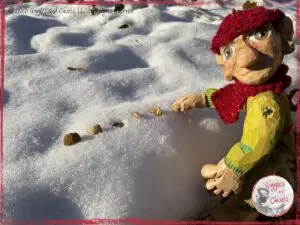 Pierre Qui Roule, a wooden puppet, creating patterns in the snow
