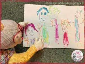 Mme Rigolotte, a wooden puppet, in front of a drawing