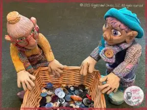 Mme Rigolotte and Petite Clothilde, two wooden puppets, looking at a baskets full of buttons