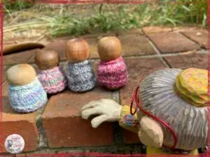 A picture of Mme Rigolotte, a wooden puppet, attentively listening to Bouilles, little mystical creatures
