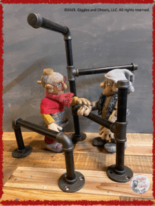 Two wooden Puppets, wondering what they could build with iron pipes