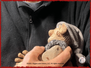 A wooden puppet in the arm of his human friend
