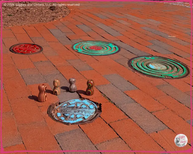 Some whimsical creatures around a manhole