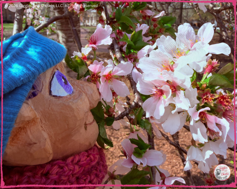 Petite Clothilde, a wooden puppet, smelling some flowers