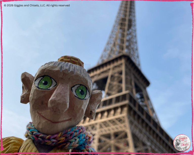 Mme Rigolotte, a wooden puppet, in front of the Eiffel tower