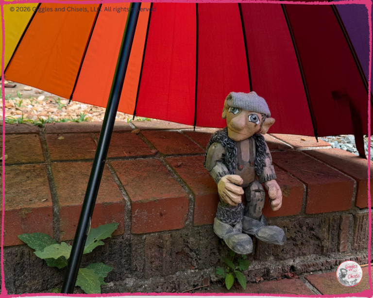 Maurice, a wooden Fellow, under a colorful umbrella
